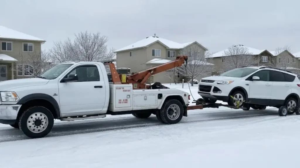 Calgary winter towing service hauling SUV on snowy residential street